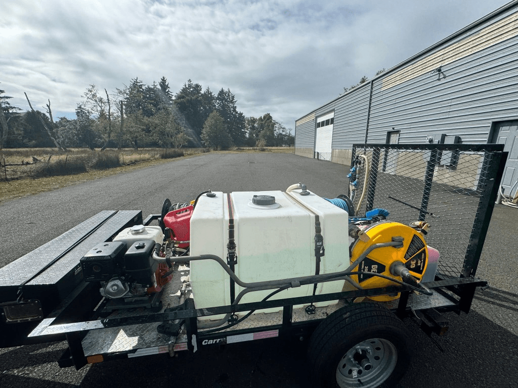 Professional pressure washing trailer with water tank, hose reels, and surface cleaner